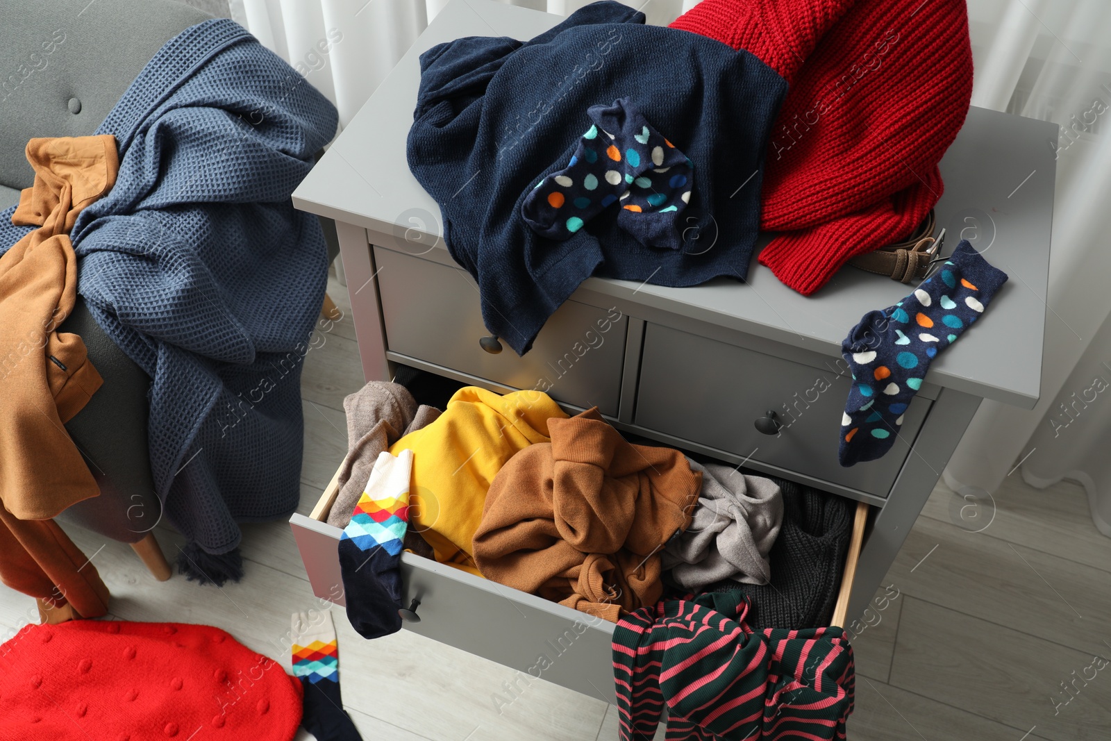 Photo of Cluttered room. Clothes in mess all around place