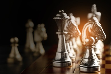 Image of Chessboard with game pieces on black background