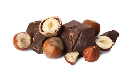 Photo of Delicious chocolate chunks and hazelnuts on white background