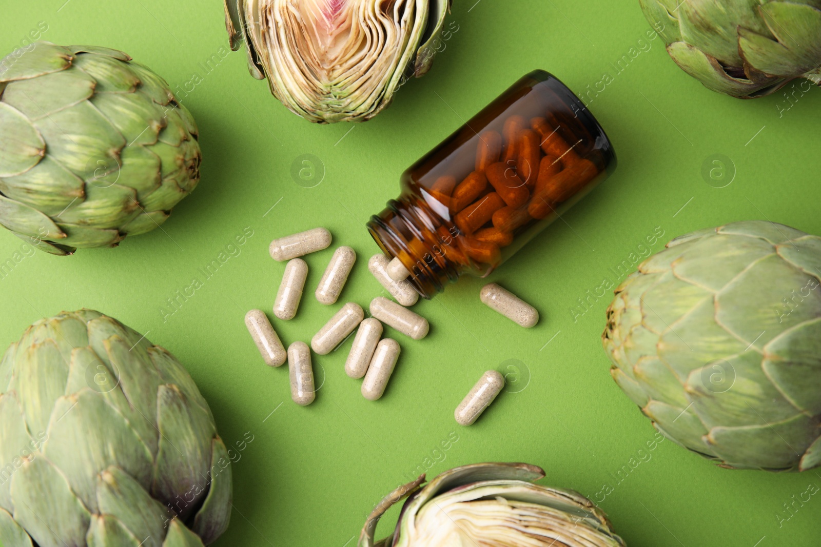 Photo of Bottle with pills and fresh artichokes on light green background, flat lay