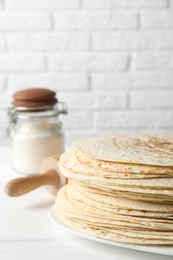Photo of Stack of tasty homemade tortillas on white table