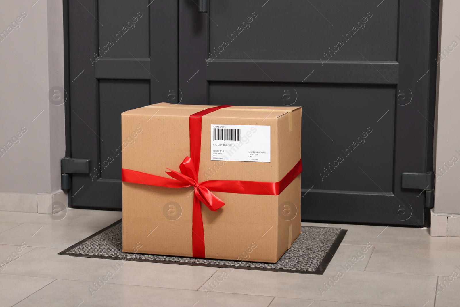 Photo of Christmas gift box on floor near door. Sending present by mail