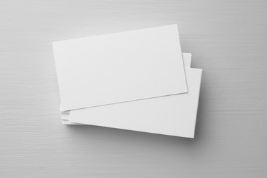 Blank business cards on white table, top view. Mockup for design