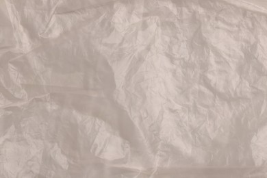 Photo of Crumpled yellow plastic bag as background, top view