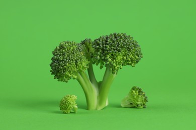 Photo of Fresh raw broccoli on light green background