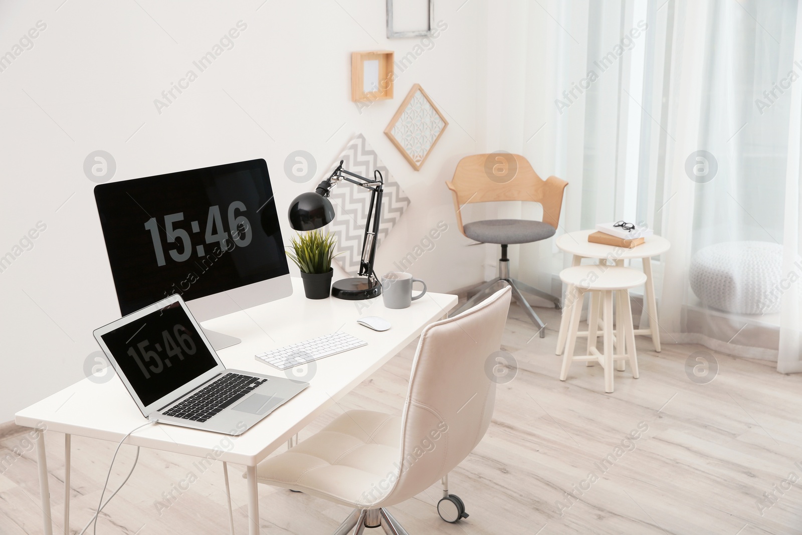 Photo of Stylish workplace with computers on table in room