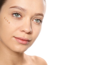 Photo of Portrait of young woman with liquid foundation on her face against white background