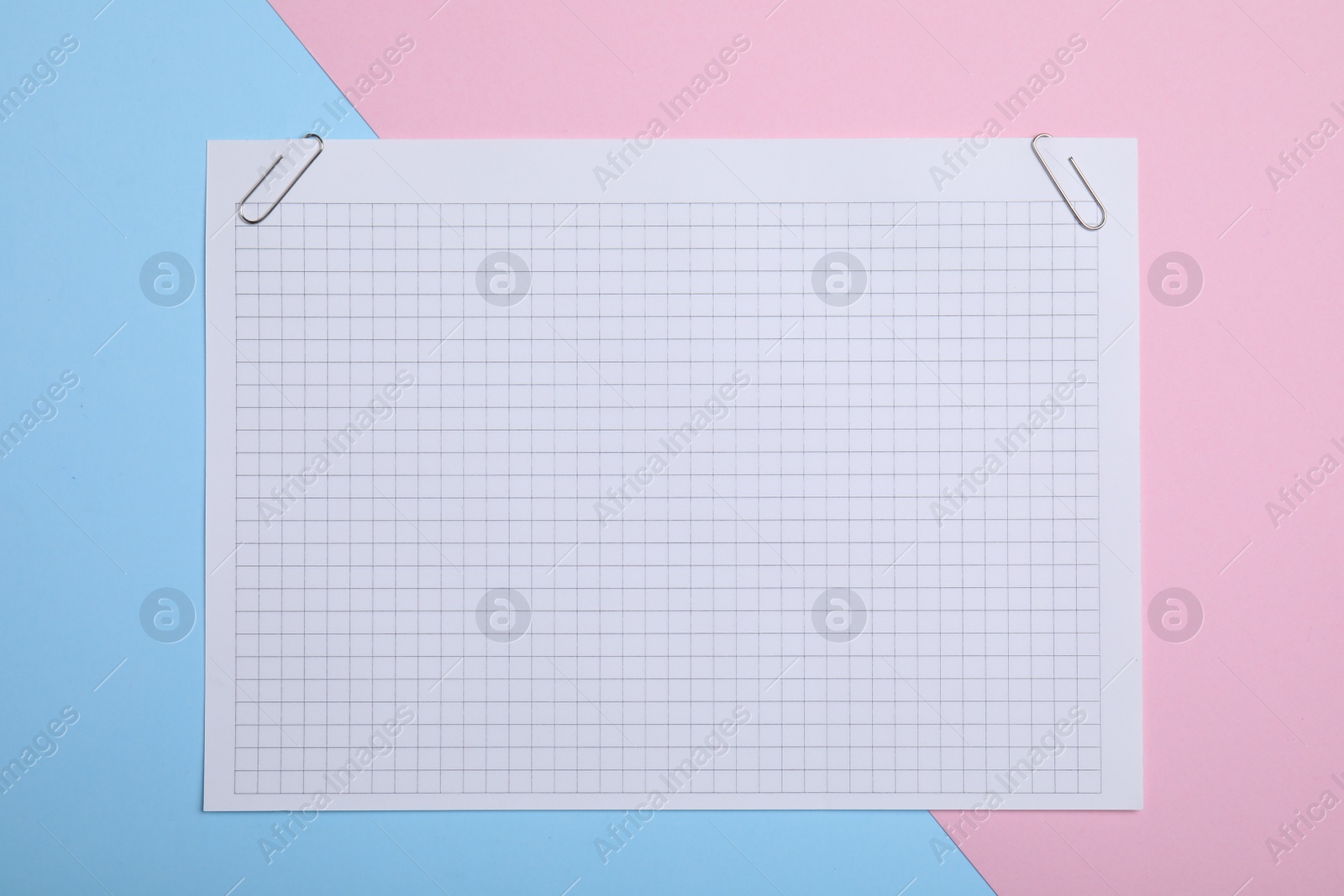 Photo of Sheet of paper with clips on color background, top view