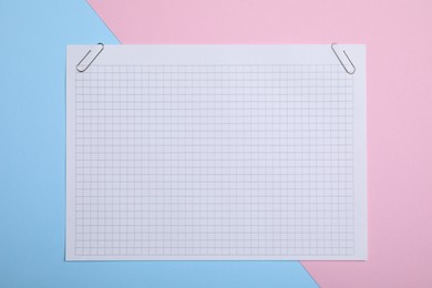 Sheet of paper with clips on color background, top view