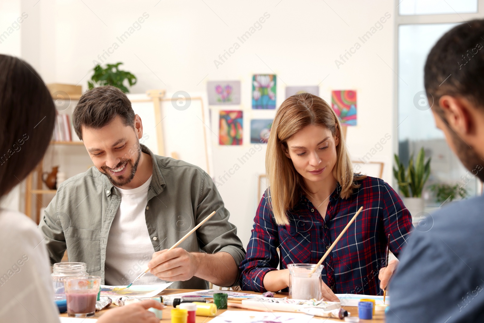 Photo of Group of students attending painting class in studio. Creative hobby