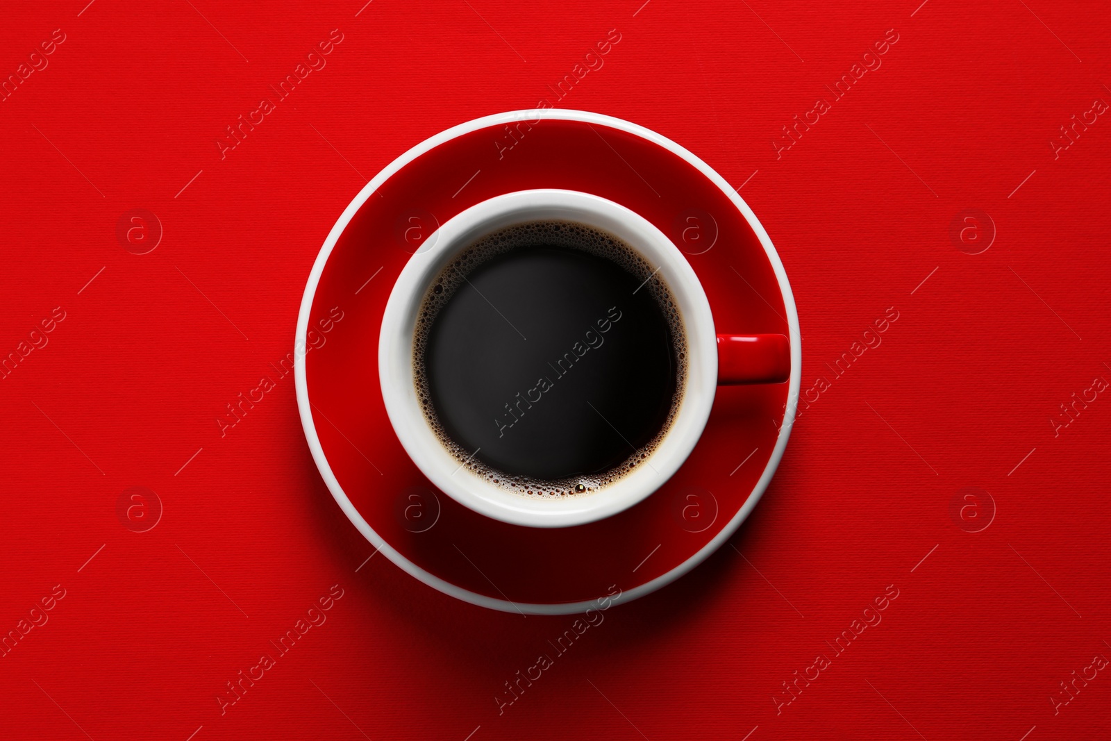 Photo of Cup with aromatic coffee on red background, top view