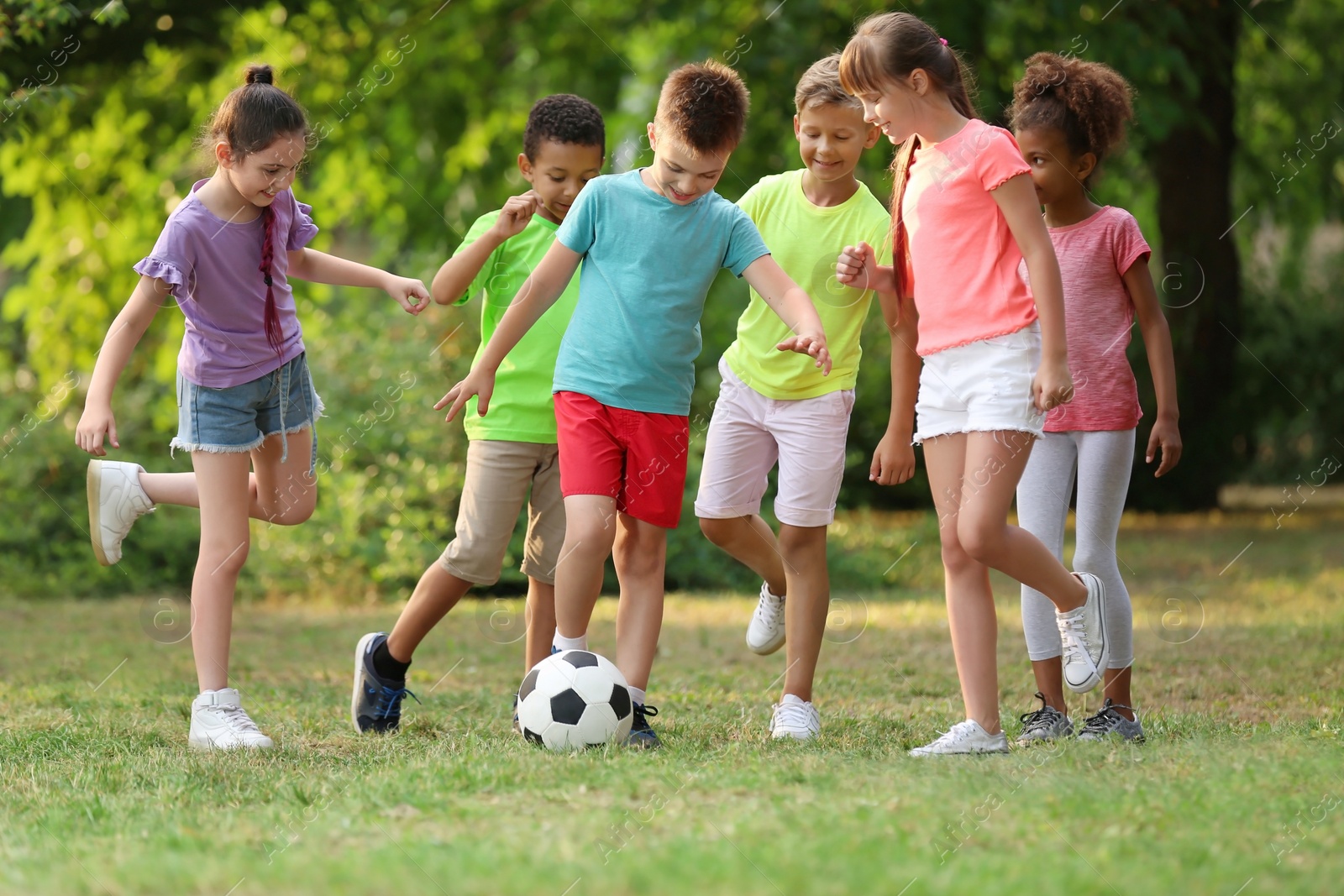 Photo of Cute little children playing with soccer ball in park
