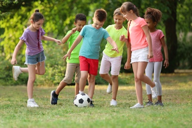 Photo of Cute little children playing with soccer ball in park