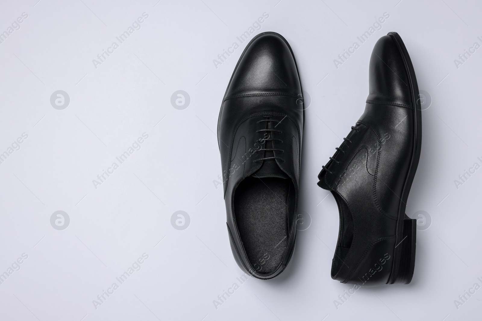 Photo of Pair of leather men shoes on white background, top view. Space for text