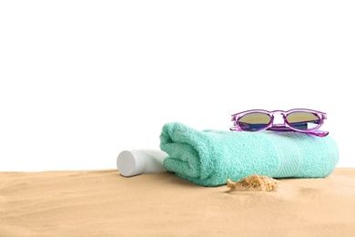 Composition with beach sand, sunglasses and towel on white background, space for text