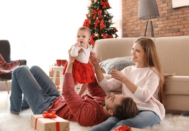 Photo of Happy couple with baby celebrating Christmas together at home