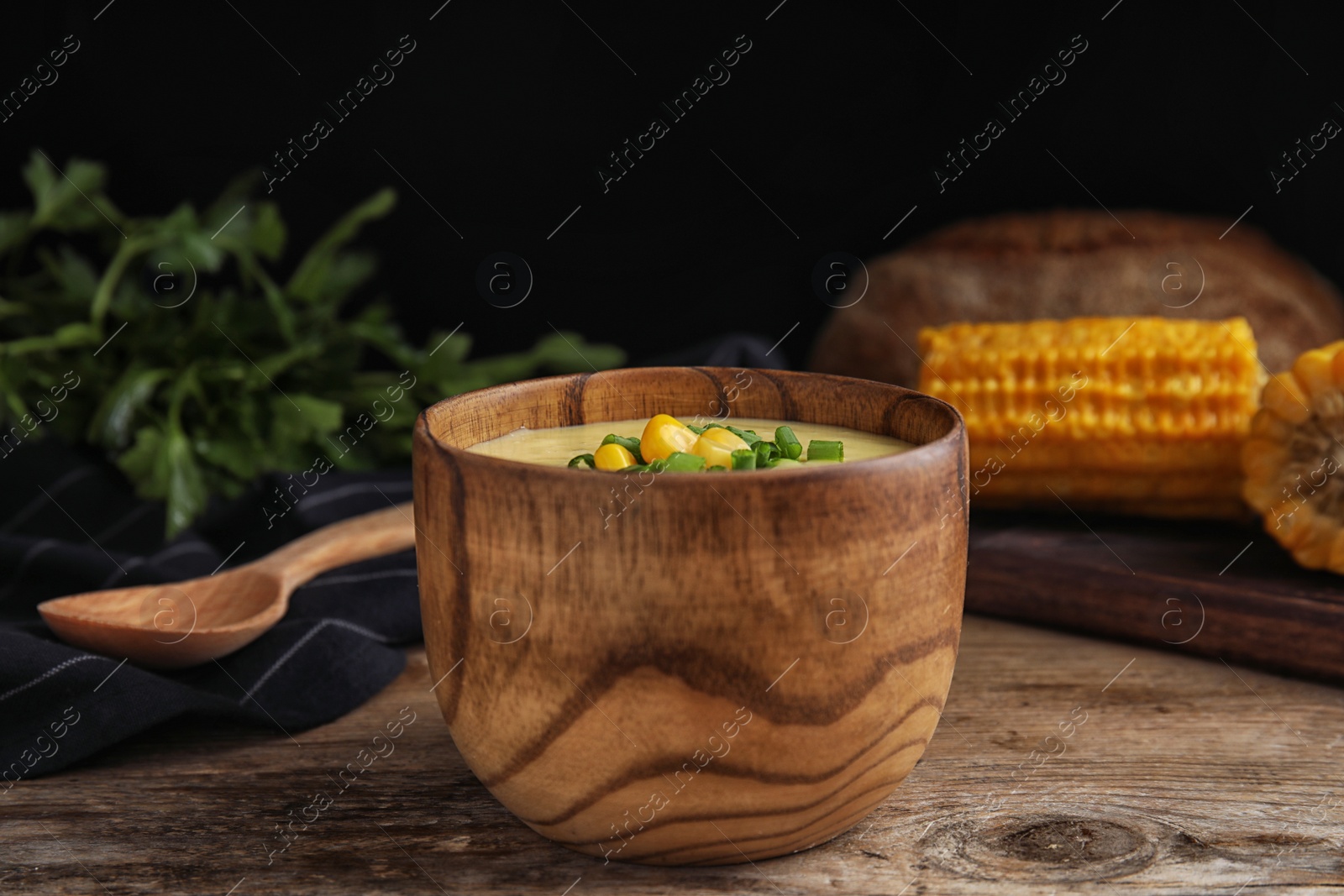 Photo of Delicious corn cream soup served on wooden table