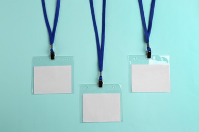 Blank badges on turquoise background, flat lay. Mockup for design