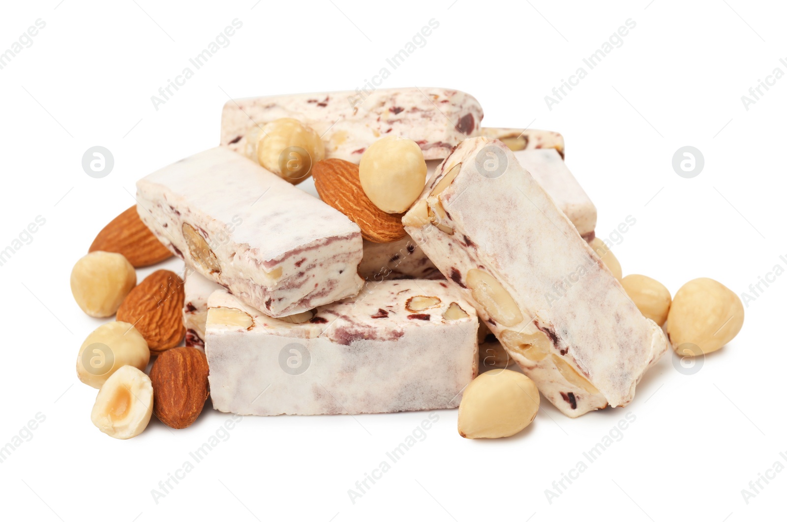 Photo of Many pieces of delicious nougat and nuts on white background