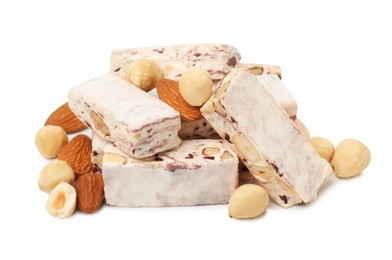 Photo of Many pieces of delicious nougat and nuts on white background