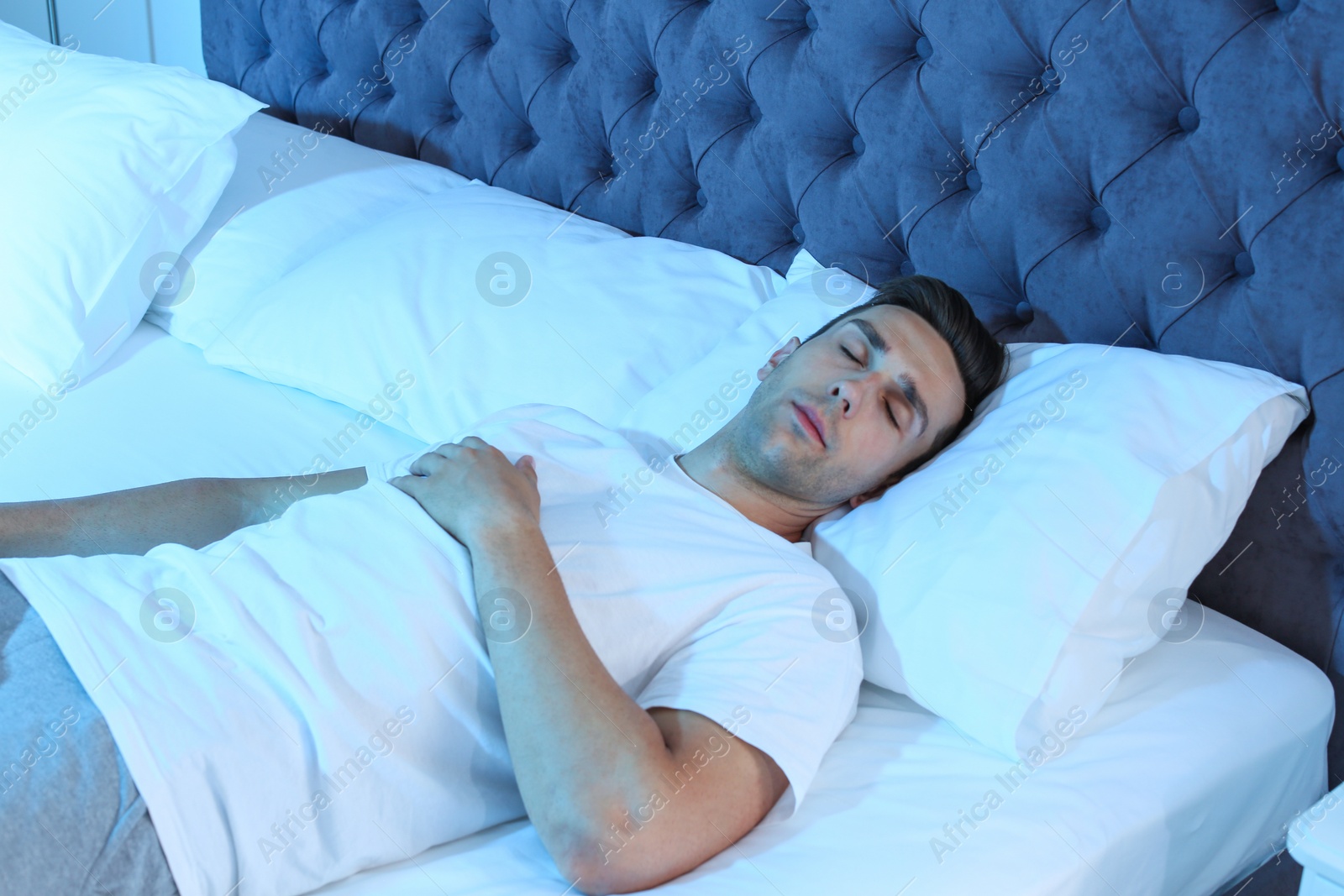 Photo of Young man sleeping in bed at night