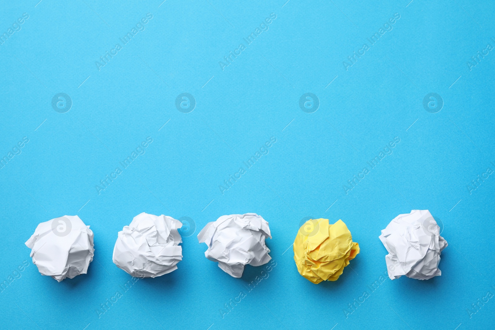 Photo of Yellow sheet of crumpled paper among white ones on color background, flat lay. Space for text