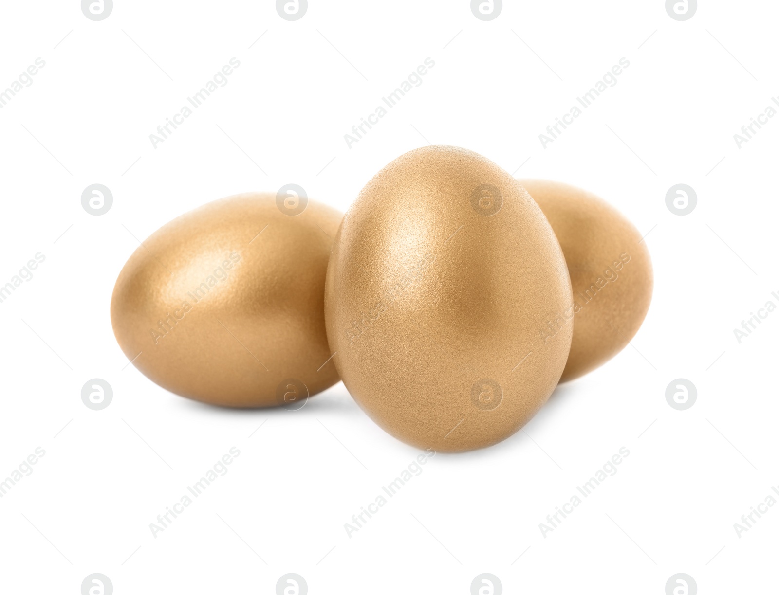 Photo of Three shiny golden eggs on white background