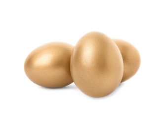 Photo of Three shiny golden eggs on white background