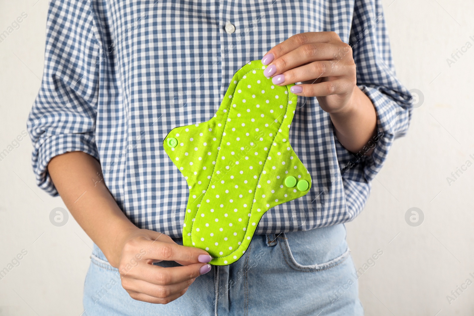 Photo of Woman holding reusable cloth menstrual pad isolated on white, closeup