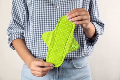 Photo of Woman holding reusable cloth menstrual pad isolated on white, closeup
