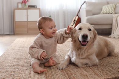 Photo of Cute little baby with adorable dog on floor at home