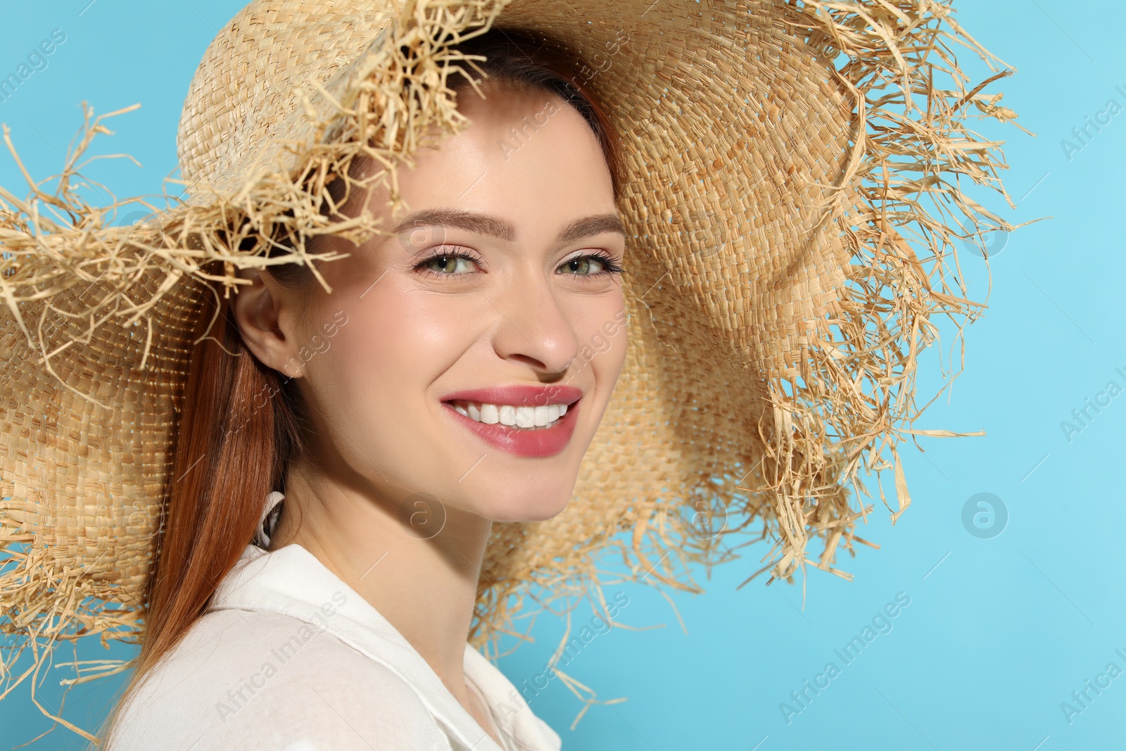 Photo of Beautiful young woman in straw hat on light blue background