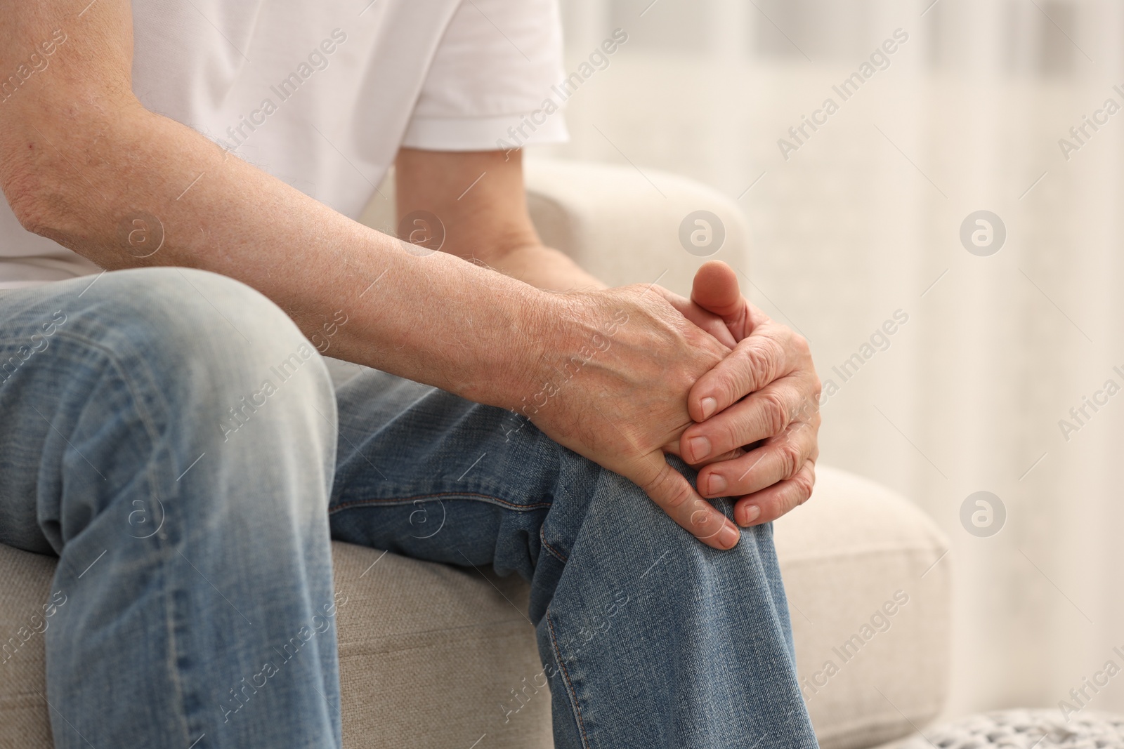 Photo of Senior man suffering from pain in leg indoors, closeup. Rheumatism symptom