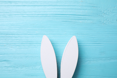 Decorative bunny ears and space for text on light blue wooden background, flat lay. Easter holiday