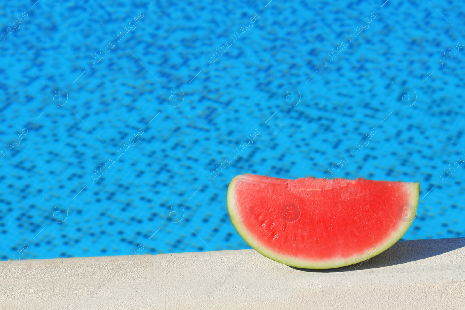 Photo of Slice of fresh juicy watermelon near swimming pool outdoors, space for text