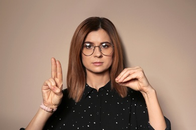 Photo of Woman using sign language on color background