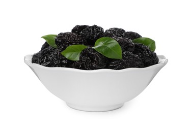 Bowl with sweet dried prunes and green leaves isolated on white