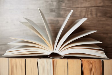 Photo of Different books against wooden background, closeup view