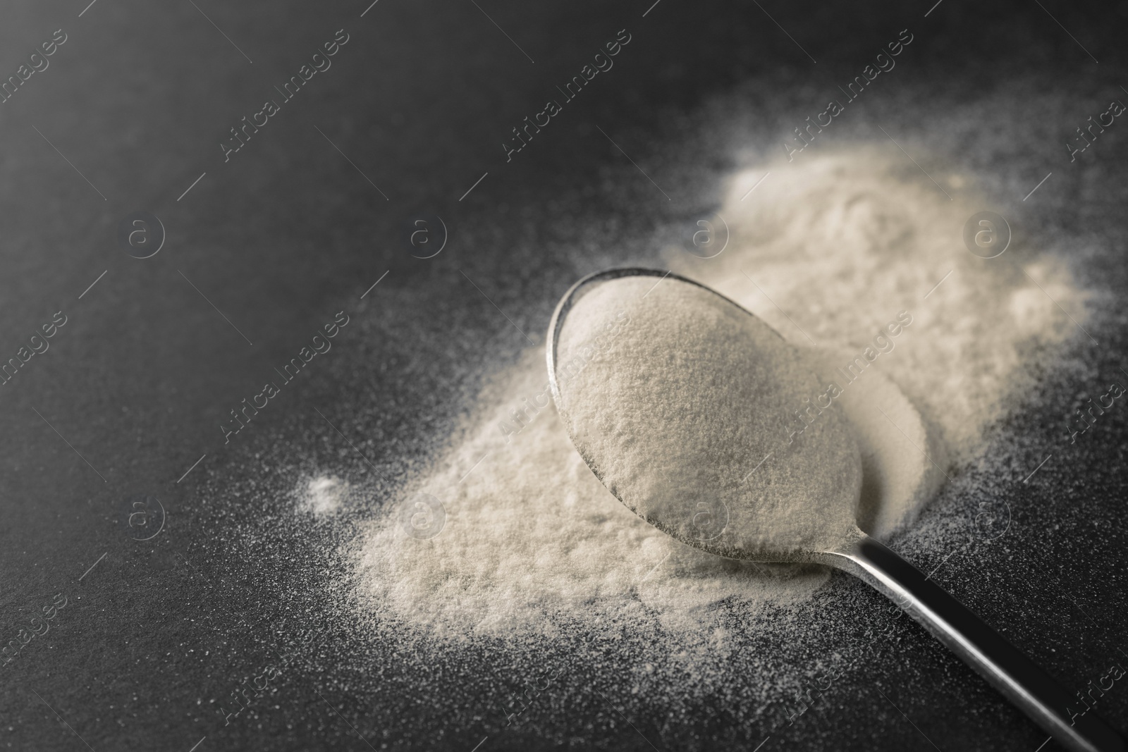 Photo of Spoon of agar-agar powder on black background, closeup. Space for text