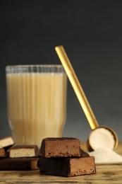 Different energy bars, protein cocktail and powder on wooden table