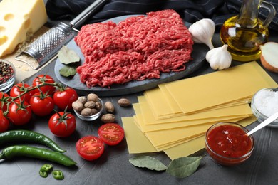 Fresh ingredients for lasagna on grey table