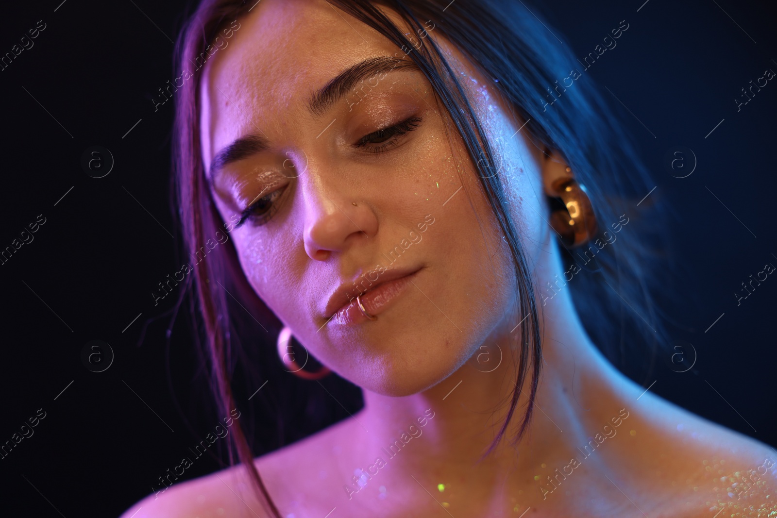 Photo of Portrait of beautiful woman on dark background in neon lights