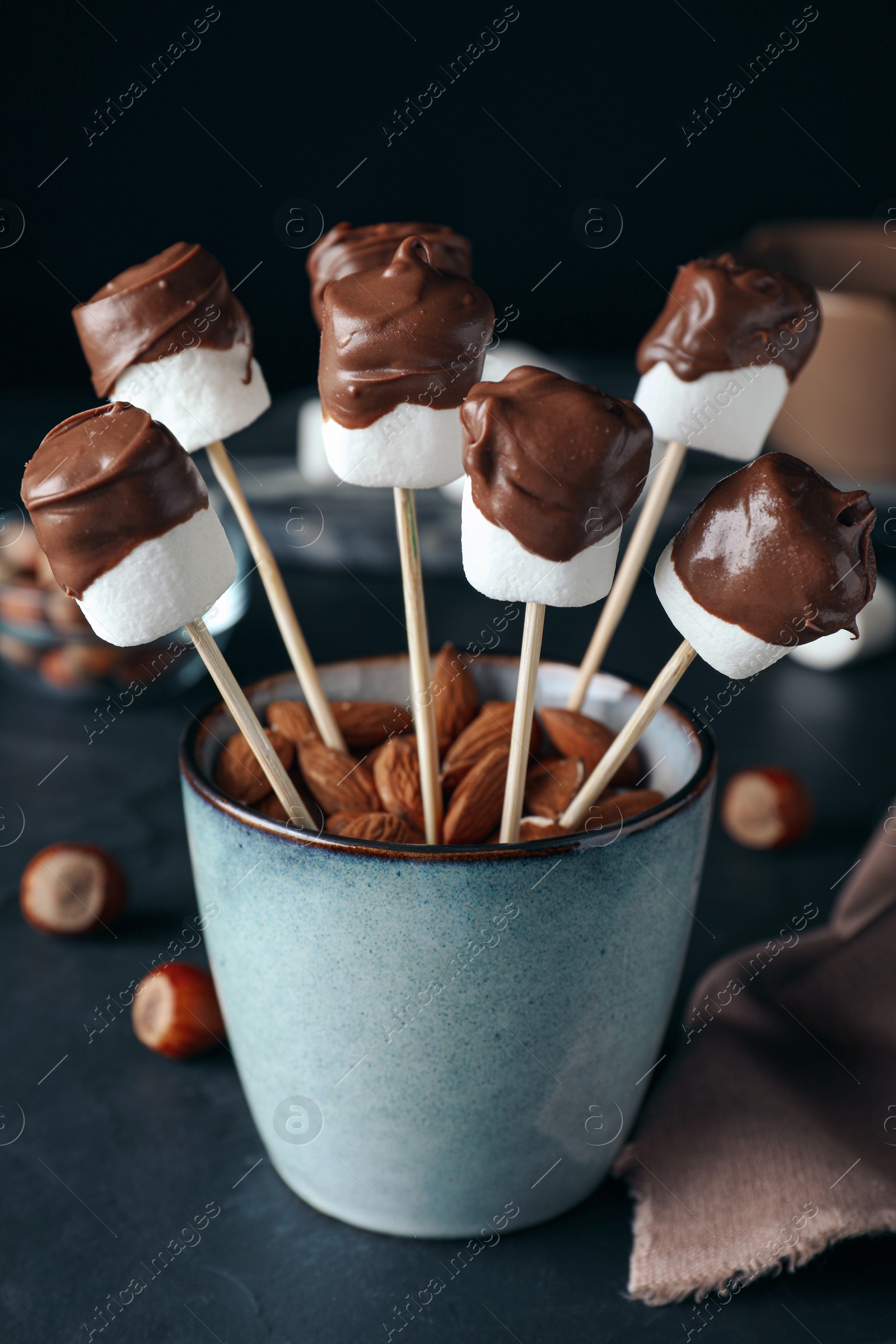 Photo of Delicious marshmallows covered with chocolate on black table