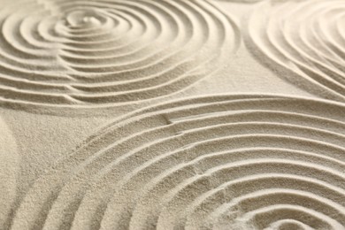 Photo of Beautiful spirals on sand, closeup. Zen garden