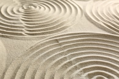 Beautiful spirals on sand, closeup. Zen garden