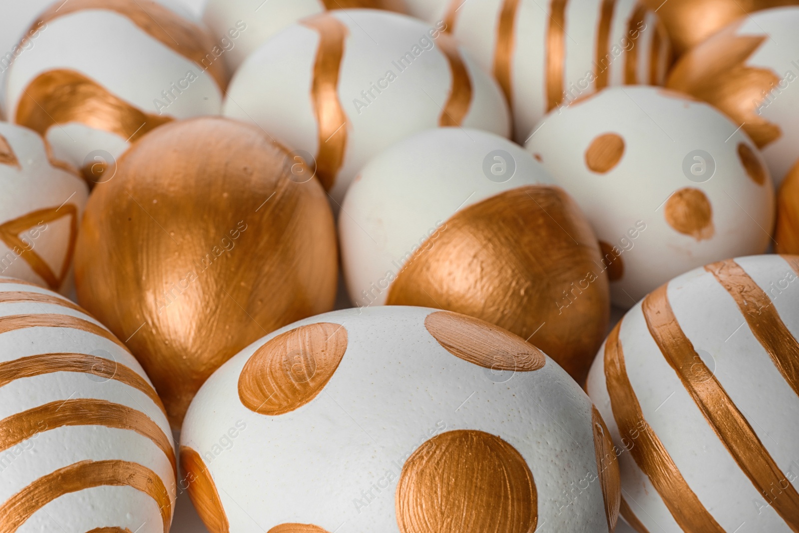 Photo of Traditional Easter eggs decorated with golden paint, closeup