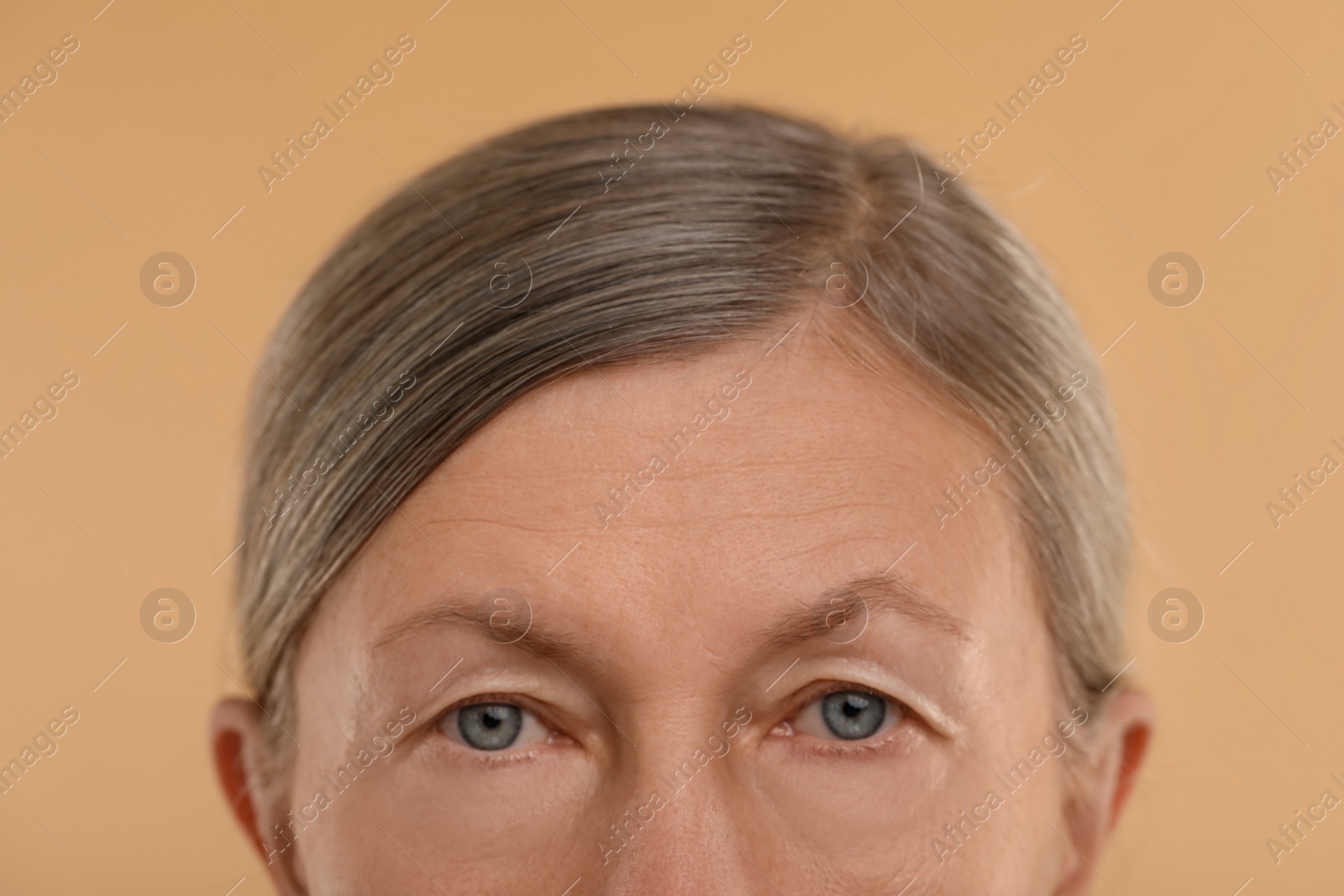 Photo of Woman with beautiful eyes on beige background, macro view