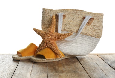 Photo of Stylish bag with beach accessories on wooden table