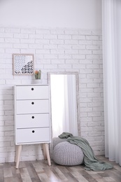 Photo of Modern room interior with large mirror and cabinet