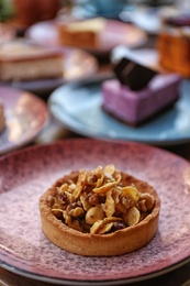 Plate with delicious cake on wooden table